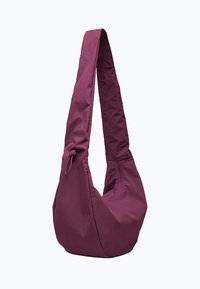 Bolso de bandolera violeta hecho de tela de nylon texturizada. Cuenta con una correa alargada y una abertura con cremallera, con contornos suaves y redondeados.