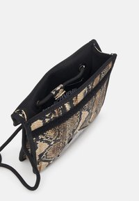 Piccola borsa a tracolla nera e beige con un motivo a pelle di piovra, dotata di chiusura con coulisse e foderata in tessuto morbido.