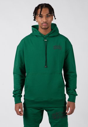Green hooded sweatshirt with a front pocket, featuring a black "WRONG FRIENDS" logo. Smooth fabric with a relaxed fit and adjustable drawstring.