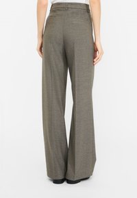 Pantaloni a gamba larga realizzati in un tessuto verde opaco e testurizzato. Presentano una vita alta, passanti per la cintura e due tasche posteriori. Finitura liscia.