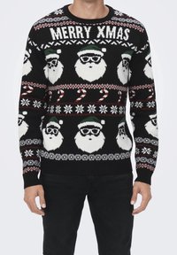 Maglione nero lavorato a maglia con un motivo di volti di Babbo Natale, bastoncini di zucchero e fiocchi di neve. Testo "MERRY XMAS" in bianco; dettagli verdi e rossi.