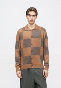 Smeđi i sivi karirani kardigan s kopčanjem na gumbe sprijeda, rebrastim manžetama i ravnim ovratnikom, izrađen od mekanog teksturiranog tkanja.