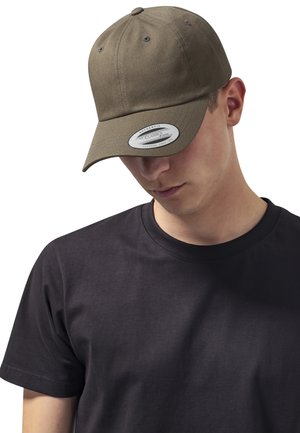 Casquette de baseball vert olive avec une visière courbée, en tissu texturé, composée de six panneaux et dotée de trous d'aération. Portée avec un t-shirt noir uni.