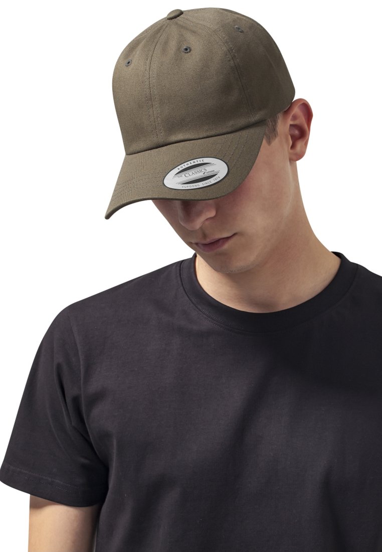 Olivegrøn baseball cap med en buet skygge, tekstureret stof, seks paneler og ventilationshuller. Båret sammen med en ensfarvet sort t-shirt.