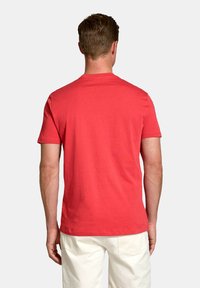 Tricou roșu din bumbac cu mânecă scurtă, având un guler rotund și o textură netedă, prezentat din spate.