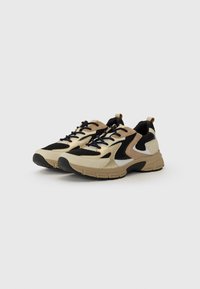 Beige and black mesh sneakers with a rounded toe, prominent laces, and a textured rubber sole. Includes beige accents and a cushioned heel.
