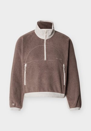 Καφέ φλις πουλόβερ με λευκά φερμουάρ, ψηλό γιακά, δύο μπροστινές τσέπες με φερμουάρ, ελαστικά μανσέτες και ελαφρύ τελείωμα.