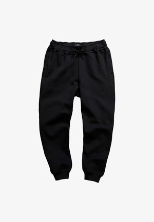 Pantaloni della tuta neri, realizzati in morbido tessuto, presentano una vita elastica con cordoncino, tasche laterali e polsini a costine alle caviglie.