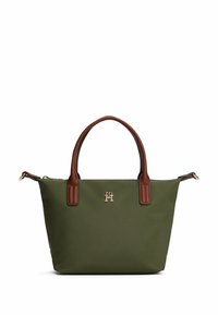 Grüne Stofftasche mit braunen Ledergriffen und -akzenten. Enthält ein goldenes Logo auf der Vorderseite und einen Reißverschluss oben.