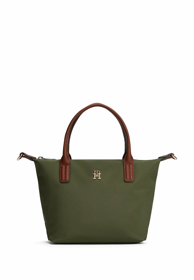 Grüne Stofftasche mit braunen Ledergriffen und -akzenten. Enthält ein goldenes Logo auf der Vorderseite und einen Reißverschluss oben.