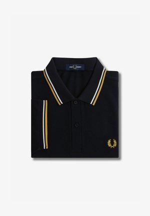 Navy polo shirt van katoen, met een drie-knopen placket, wit en gouden gestreepte kraag, en geborduurd gouden logo op de borst.
