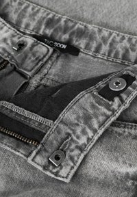 Sivi teksas tkanina sa izlizanim teksturom, s patentnim zatvaračem, crnim unutarnjim postavom i oznakom marke „TWO SOON“. Metalni ukrasi.