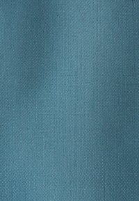 Modrá látka s jemnou tkanou strukturou a jemnými diagonálními stínovými vzory přes povrch.