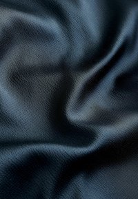 Melna satīna audums ar gludu tekstūru, piedāvājot nedaudz spīduma un maigus krītošus salocījumus, radot bagātīgu, greznu izskatu.