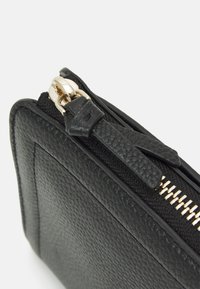 Black textured leather pouch with a gold zipper and pull tab, featuring a rectangular shape and smooth edges.
