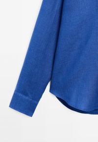 Blaues Langarmhemd aus strukturiertem Stoff, mit abgerundetem Saum und Knopfverschluß an den Manschetten. Glatte Oberfläche mit einer satten Farbe.