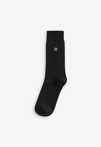 Black cotton sock with a ribbed cuff, featuring a small gray logo on the side. Smooth texture, standard tube shape.