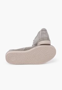 Gray textile shoe with a textured upper, reinforced stitching, and a rubber outsole featuring a patterned tread for grip.