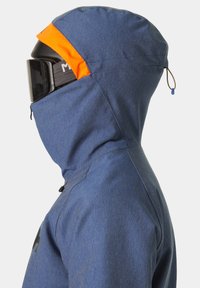 Giacca isolante blu con cappuccio, caratterizzata da un accento arancione. Tessuto testurizzato e colletto alto, progettata per il freddo con una vestibilità sicura.