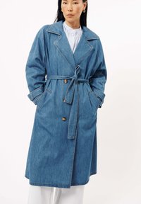Denim trenchcoat met een ceintuur in de taille, grote kraag en dubbele knopen sluiting. Voorzien van zijzakken en een comfortabele pasvorm.