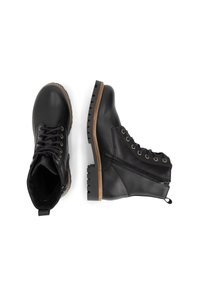 Zwarte leren enkelboots met veter-sluiting aan de voorkant, zijkant met ritssluiting, robuuste gestructureerde zool en tan accenten op de rand van de zool.