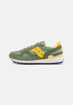 Green suede and mesh sneaker with yellow accents, laces, and logo; features a white midsole and black rubber outsole.