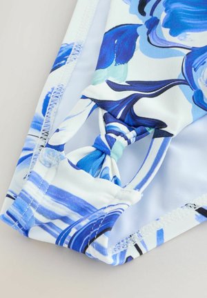 Parte inferior de bañador con estampado floral en tonos azules y blancos, con un detalle de nudo en la cintura y tejido suave y elástico.