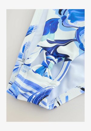 Plavky s květinovým vzorem v odstínech modré a bílé, s uzlovým detailem na pasu a hladkou, elastickou látkou.