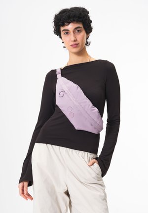 Lila Umhängetasche aus weichem Stoff, mit einem geschwungenen Design, verstellbarem Tragegurt und runden Akzenten in Rot und Blau.