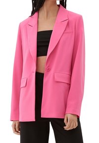 Blazer rose sur mesure avec un design structuré, fermeture à un bouton, revers crantés, et deux poches avant ; tissu lisse et léger.