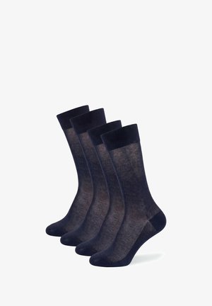 Vier paar zwarte, semi-transparante crew sokken naast elkaar gelegd op een witte achtergrond.