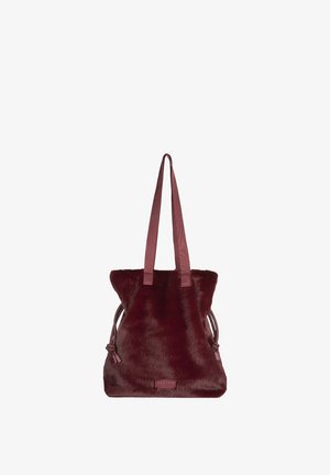 Bordeauxrode faux fur tote tas met twee stoffen handvatten, trekkoordsluiting en een leren merklabel aan de voorkant. Zachte textuur.