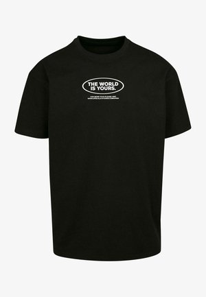 Sort bomuld t-shirt med rund halsudskæring. Forsiden har hvid tekst der læser "VERDEN ER DIN." og et hjemmeside-link nedenfor. Standard pasform.