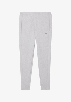 Graue Jogginghose mit einem elastischen Bund, seitlichen Taschen und gerippten Bündchen. Mit einem dezenten Logo am linken Oberschenkel.