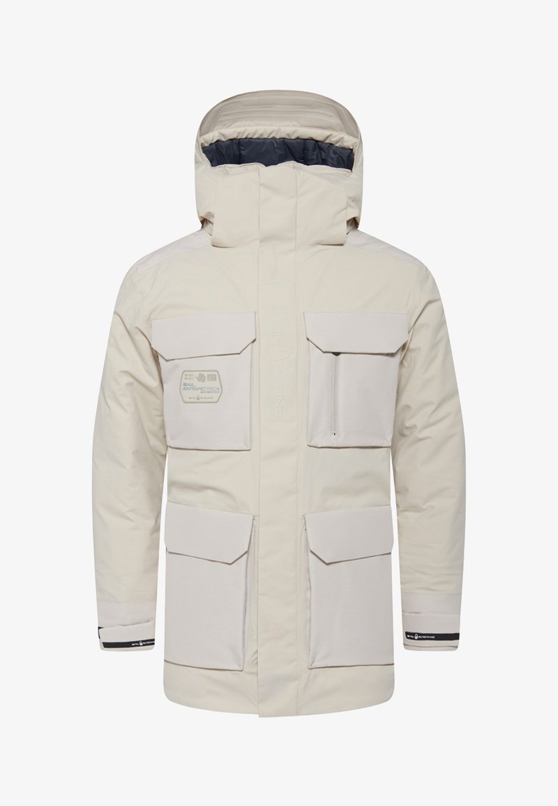 Beige Isolierjacke mit hohem Kragen, mehreren großen Fronttaschen und einer mit Reißverschluss versehenen Brusttasche, die über ein dezentes Logo-Detail verfügt.