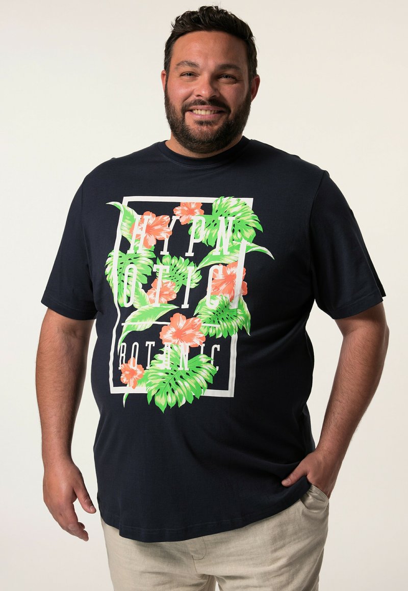 Námořnická modrá trička z bavlny, která má květinový grafický motiv v odstínech zelené a korálové, s designem obdélníkového bílého textového pole.