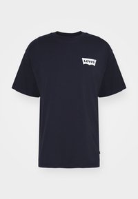 T-shirt en coton bleu marine à manches courtes, col rond, avec un logo Levi's blanc imprimé sur le côté gauche de la poitrine.
