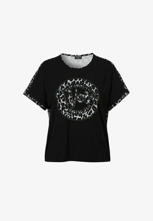 T-shirt noir à manches courtes, avec un motif rond incluant un texte argenté "Wow" et un accent imprimé léopard sur les manches.