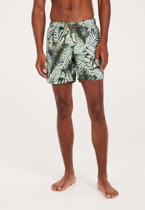 Badeshorts mit einem tropischen grünen Blättermuster auf schwarzem Hintergrund, einem elastischen Bund und einem Kordelzug.