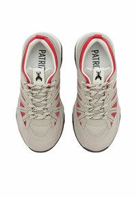 Sneaker beige con tomaia in mesh, accenti rossi e lacci grigi. Suola in gomma nera e dettagli testurizzati sulla punta e sui lati.