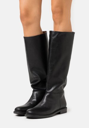 Botas de piel negra hasta la rodilla con una textura suave, punta redonda y suela plana. El diseño es simple, sin embellishments visibles.