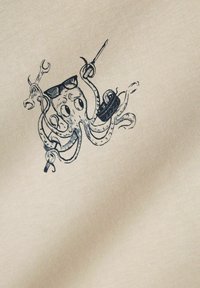 Beige stof met een zwarte illustratie van een octopus die een zonnebril draagt, gereedschap en een band vasthoudt. Gedetailleerd lijnwerk en een gladde textuur.