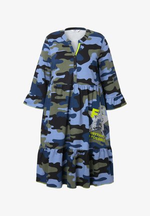 Robe à motif camouflage dans des tissus bleu, vert et noir. Elle possède un col à boutons, des manches évasées et un ourlet à volants avec un texte graphique.