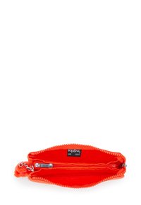 Bright orange Kipling pouch with two zippered compartments and a small furry keychain attached to the zipper pull.