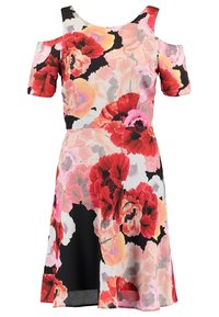 Robe florale avec des manches dénudées, présentant principalement des fleurs roses et rouges sur un fond crème et noir. Tissu lisse, coupe à mi-genoux.