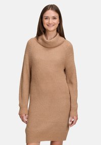 Beige Strickkleid mit Rollkragen, langen Ärmeln und Rippstruktur. Verfügt über eine lässige Passform und eine Länge bis zur Mitte des Oberschenkels.