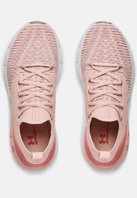 Roze sportieve schoenen met een textuur gebreid bovenwerk, geweven veters en een witte rubberen zool met een subtiele accent near de hiel.