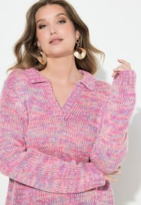 Långärmad, rosa stickad tröja med krage och V-ringning. Har en blandad textur med ljusblå och lila accenter. Mysig och lös passform.