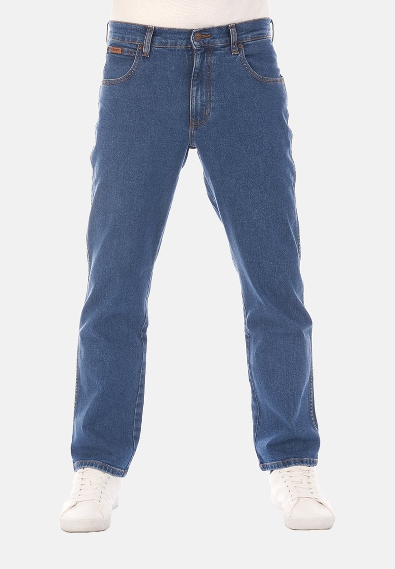 Jean bleu en denim pour homme à coupe droite porté avec des baskets blanches, présenté de la taille aux pieds sur fond blanc.