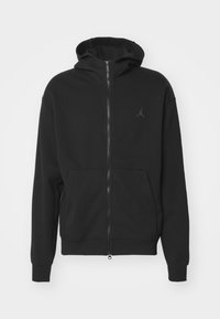 Sort zip-up hoodie lavet af blødt stof, med en kengurulomme, ribbede håndled og en lille logo accent på brystet.